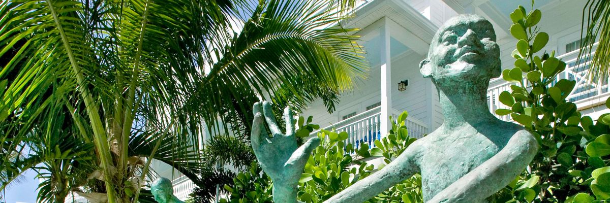 Turquoise statues amid tropical foliage.